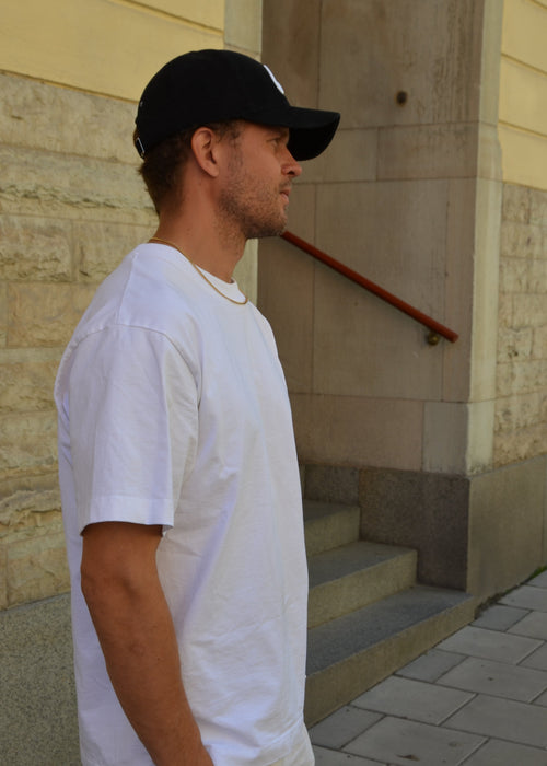 Black corduroy unisex cap with embroidery, structured front and adjustable metal buckle strap